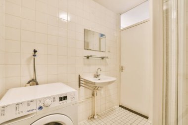 a laundry room with a washer and dryer in the corner, which is white tile on the floor