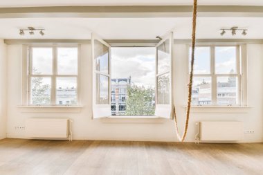 Boş bir oda, iki penceresi ve tavandan pencerenin önüne kadar sarkan bir ip.