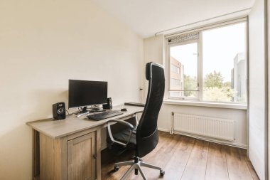 a home office with a desk, chair and computer monitor on the table in front of the window looking out