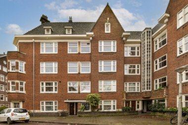 an apartment building with cars parked in the driveway and two bicycles parked on the street next to each other buildings
