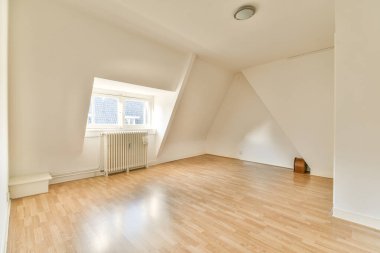 Odasında ahşap döşeme ve beyaz duvarlar olan boş bir oda çok temiz, ama ışık yok.