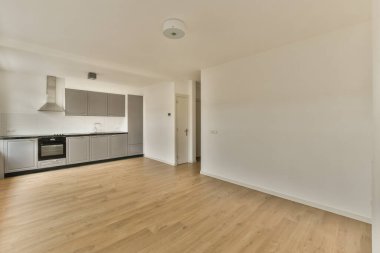 an empty living room with wood flooring and light colored cabinets in the corners on the wall is white