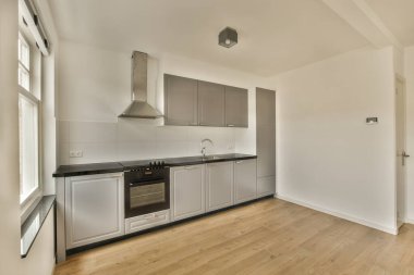 an empty kitchen with wood floors and stainless appliances on the counter tops in this photo is taken from the inside