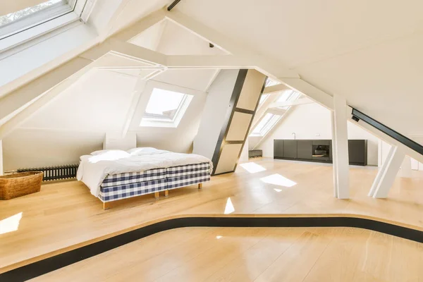 an attic bedroom with wood flooring and skylights above the bed, as well as it is in this photo