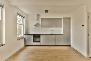 an empty kitchen with wood flooring and white cupboards in the room is very clean, ready to use