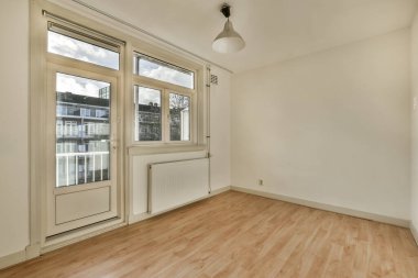 an empty room with wood flooring and large windows looking out onto the street in front of the apartment building