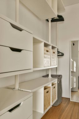 the inside of a house with wood flooring and white cupboards on either side of the room, there is an open door
