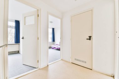 an empty room with white doors and blue drapes on the door is open to reveal another room that has no furniture