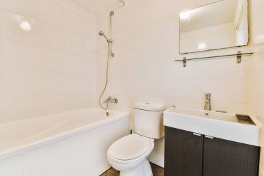 a bathroom with white tiles on the walls and wood flooring around the tub, toilet, sink and mirror