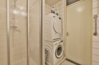 a laundry room with a washer and dryer on the wall next to an open door that is closed