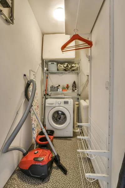 the inside of a laundry room with a vacuum and dryer on the floor in front of the washer