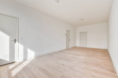 an empty room with white walls and wood flooring the room is very clean, but there is no light