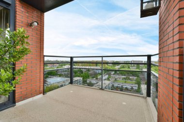 Amsterdam, Netherlands - 10 April, 2021: a balcony with some plants and buildings in the background on a sunny day, as seen from an apartment window