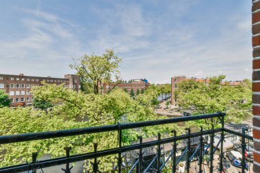Amsterdam, Netherlands - 10 April, 2021: a balcony with trees and buildings in the background, taken from an apartment window looking out to the street below