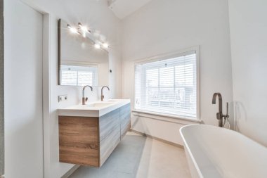 Banyo küveti, lavabosu ve penceresi olan arka duvardan odanın diğer tarafına.