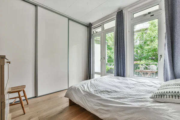 Ein Bett Einem Schlafzimmer Mit Schiebetüren Zum Innenhof Und Bäumen — Stockfoto