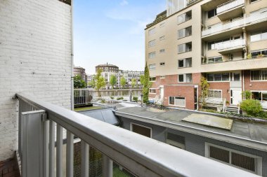 Amsterdam, Netherlands - 10 April, 2021: some cars parked on the side of a street in an urban area with bricked buildings and blue sky above