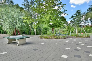 Amsterdam, Netherlands - 10 April, 2021: a house in the middle of a park with lots of leaves on the ground and trees lining the path leading up to it
