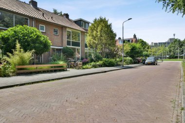 the back yard with plants and flowers in pots on either side of the house, looking towards the rear garden