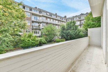 Amsterdam, Hollanda - 10 Nisan 2021: Arka planda ağaçlar ve evler olan bir dış alan, güneşli bir günde nasıl gittiğini göstermek için alındı