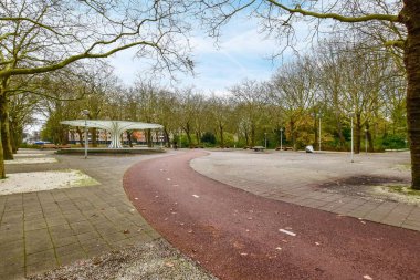 Yolunda hiç insan olmayan boş bir park, ve önünde bazı ağaçlar - arkasında yanan alan