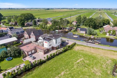 Amsterdam, Hollanda - 10 Nisan 2021: yukarıdan köyün ve nehrin havadan görünüşü, öndeki evlerin görüntüsü - insansız hava aracından alındı