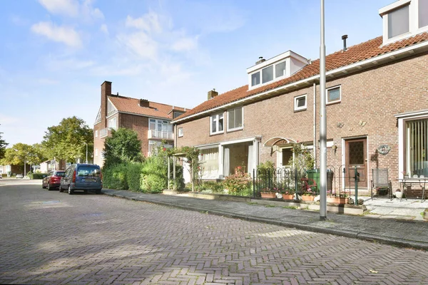 アムステルダム オランダ 2021 家や車が横に停まっている通り その前に路地につながるレンガ舗装された道路です — ストック写真