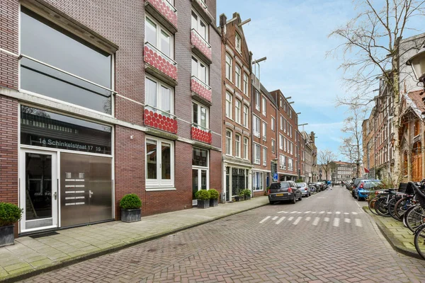 2021年4月10日 荷兰阿姆斯特丹 一条砖墙街道 旁边停着自行车 后面的地面上有建筑物 所有的东西都排成了一排 彼此的砖块成了一排 — 图库照片