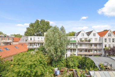 Amsterdam, Netherlands - 10 April, 2021: some cars parked on the side of a street in an urban area with bricked buildings and blue sky above