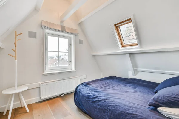 2つの窓のある部屋の隅にベッドと反対側の青の快適さ — ストック写真