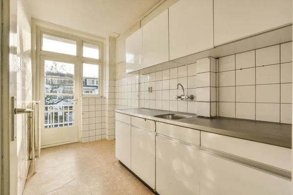Een Keuken Met Witte Kasten Zwarte Aanrechtbladen Vloer Voor Een — Stockfoto