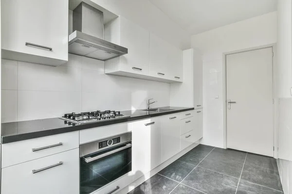 stock image a kitchen with white cupboards and black counter tops on the counters in this photo is taken from the inside