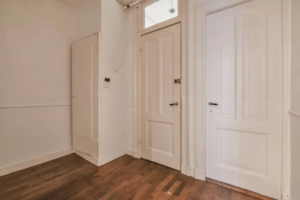 Ein Leerer Raum Mit Holzböden Und Weißen Türen Auf Beiden — Stockfoto