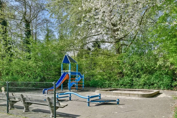 Uma Área Parque Infantil Com Uma Corrediça Montada Meio Cercada — Fotografia de Stock