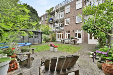Amsterdam, Netherlands - 10 April, 2021: a brick building on the side of a street with cars parked in front and trees lining the sidewalk behind it