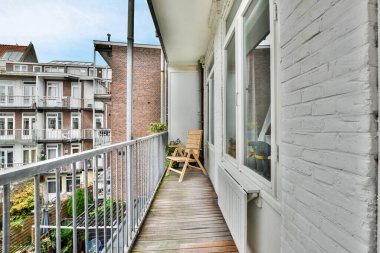 Amsterdam, Hollanda - 10 Nisan 2021: Ahşap döşemeli ve beyaz kenarlı bir balkon, sokağa bakıyor.