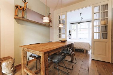 Odanın ortasında ahşap bir masa ve sandalyeli bir yemek odası var.