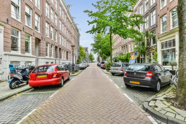 Amsterdam, Hollanda - 10 Nisan 2021: kaldırımlara ve binalara park edilmiş bir şehir sokağı, tepeden çekilmiş