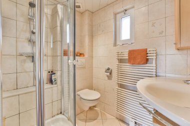 Tuvaleti ve duş kabini olan bir banyo hemen yanında lavabo, ayna ve havlu asacağı var.