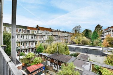 Amsterdam, Hollanda - 10 Nisan 2021: Önünde evler ve ağaçlar olan bir dış alan - yatak odamın penceresinden sokağa bakan bir görüntü alındı