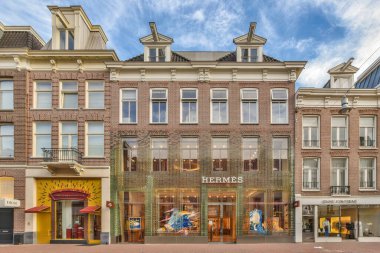 Amsterdam, Hollanda - 10 Nisan 2021: Şehir merkezinin ortasında bir bina. Kaldırımda yürüyen insanlar ve arkasında binalar var.