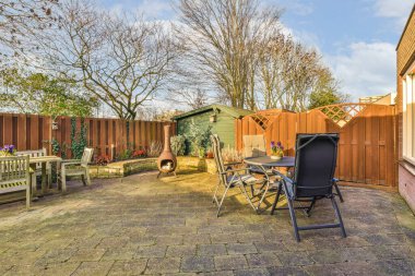 Arka bahçesinde sandalyeler, masalar ve arka bahçeye kurulmuş açık hava yemekleri olan bir yer.