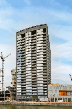 Amsterdam, Hollanda - 10 Nisan 2021: etrafında vinçler bulunan bir inşaat alanının önüne bir su kütlesi inşa ediliyor