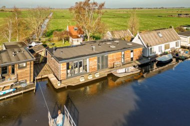 Amsterdam, Hollanda - 10 Nisan 2021: Bir teknesi yan yana yüzen bazı evler ve iki tekne yan yana park edilmiş.