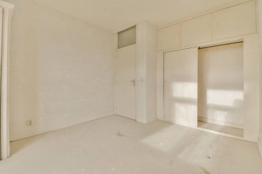 Duvarında beyaz duvarlar ve dolaplar olan boş bir oda, içinde ne kapı ne de pencere var.