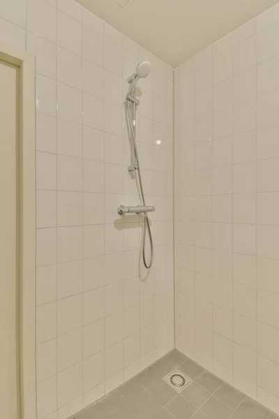 浴槽の周りの壁やタイルに白いタイルが付いたシャワールームで — ストック写真