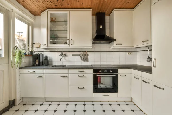 地板上有黑白瓷砖的厨房 包括烤箱 微波炉 洗碗机和水池 — 图库照片