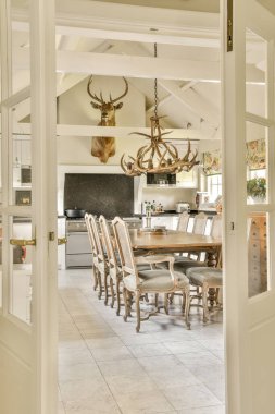 Amsterdam, Hollanda - 10 Nisan 2021: Oturma odasının kapısının üstündeki duvarda geyik kafası olan bir evde mutfak ve yemek alanı