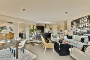 Kanepenin önünde kanepe, sandalye ve sehpa olan bir oturma odası siyah ve beyazdır.