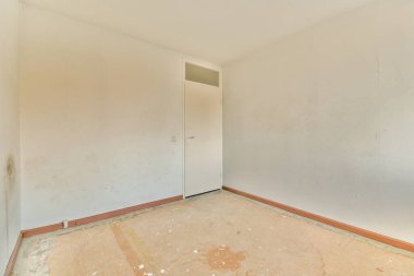 Bu fotoğrafta beyaz duvarları olan ve yere boya döken boş bir oda, tek bir kapı yok.